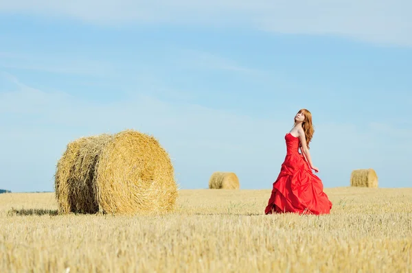 Bride in red wedding dress in a field — Stock Photo, Image