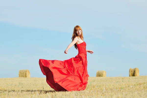 Panna młoda w czerwona suknia ślubna w polu — Zdjęcie stockowe