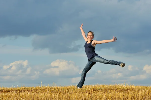 Красивая девушка в гимнастическом прыжке против голубого неба — стоковое фото