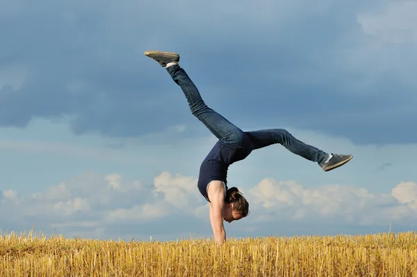 Schönes Mädchen beim Handstand auf einer Wiese — Stockfoto