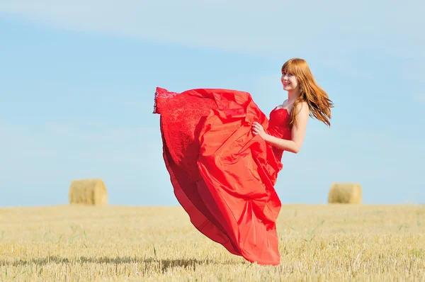 Bride in red wedding dress in a field — Stock Photo, Image