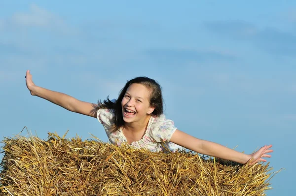 Vacker flicka njuter av naturen i höet — Stockfoto