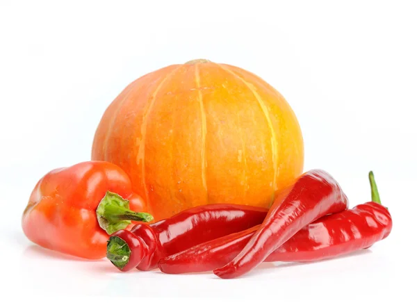 Studio shot of orange pumpkin with red peppers — Stock Photo, Image