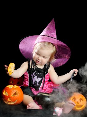 Cadılar Bayramı bebek siyah arka plan üzerinde oyulmuş kabak ile cadı