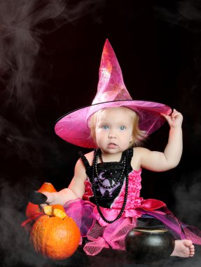 Cadılar Bayramı bebek siyah arka plan üzerinde oyulmuş kabak ile cadı
