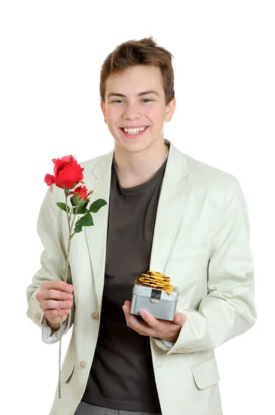 De dag van Valentijnskaarten. Portret van jonge man houdt de rose en cadeau over de witte achtergrond — Stockfoto