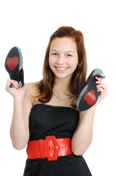 Retrato de una adolescente sonriente sosteniendo zapatos de tacón alto aislados sobre el fondo blanco — Foto de Stock