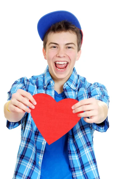 Smiling teenage boy holding valentine heart cut out from red paper over white background — Stock Photo, Image