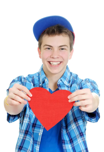 Smiling teenage boy holding valentine heart cut out from red paper over white background Royalty Free Stock Images