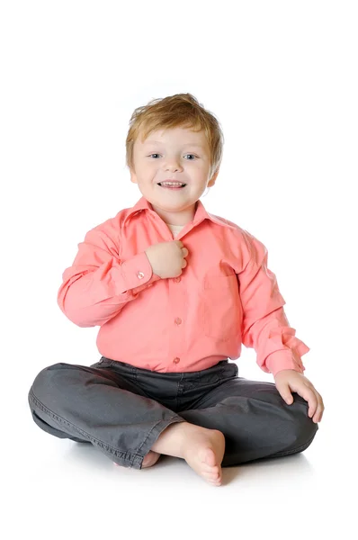 Śliczny chłopczyk uśmiechając się, siedząc na podłodze, łapka, na białym tle — Zdjęcie stockowe