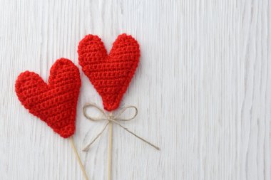 Beyaz ahşap arka planda kırmızı kalpler