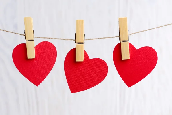 Red hearts hanging on wooden background — Stock Photo, Image