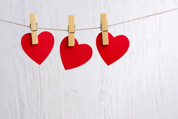 Red hearts hanging on wooden background — Stock Photo, Image