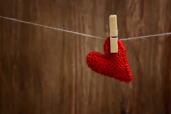 Corazón rojo colgando sobre fondo de madera — Foto de Stock