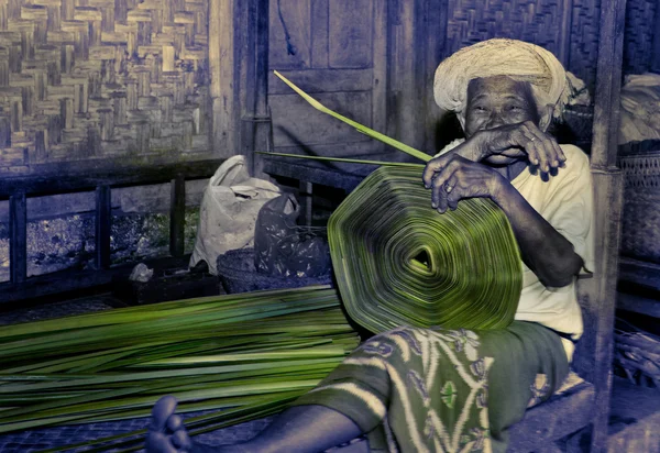Mujer balinesa tejiendo una estera — Foto de Stock