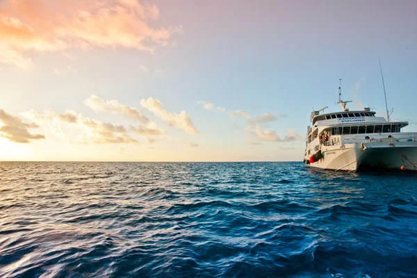 曇り空の下の波線の海に浮かぶ船 — ストック写真