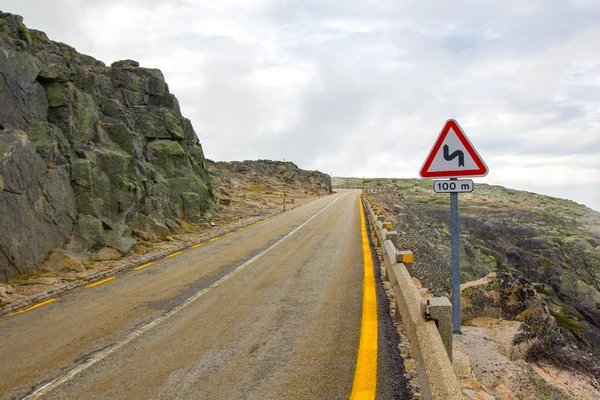 Mountain road, traffic warning sign double bend — Stock Photo, Image