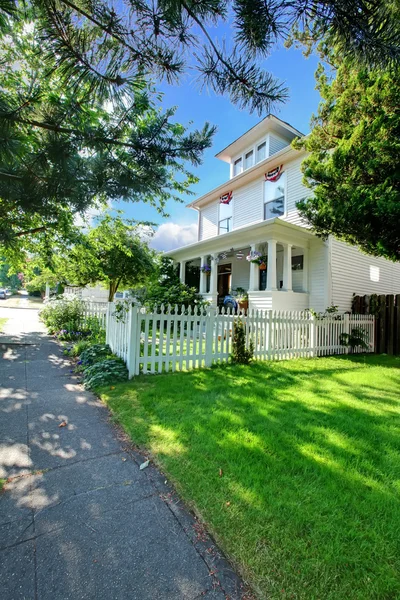 Casa blanca con césped verde y cerca cerca de la pasarela . —  Fotos de Stock