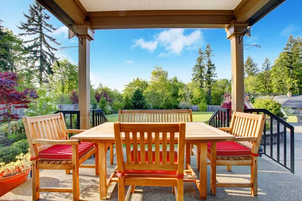 Overdekt terras met eetkamer en mooie achtertuin. — Stockfoto