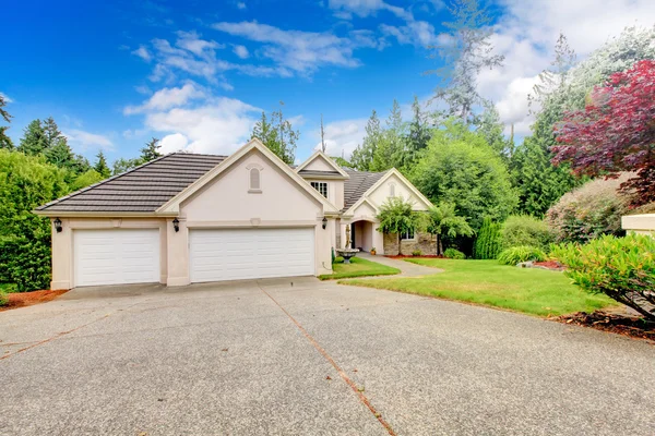 Grande belle maison beige et gris garage extérieur pendant l'été . — Photo