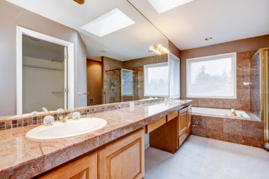 büyük lüks banyo küvet ile kırmızı granit mutfak tezgahı.
