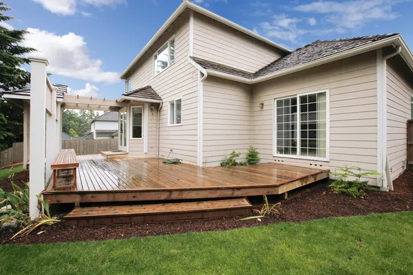 Nagy bézs ház a verandán, a kertben. — Stock Fotó