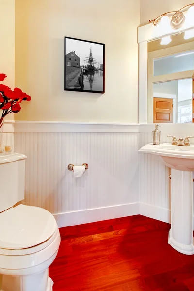 Blanco pequeño baño elegante con suelo de madera roja . — Foto de Stock