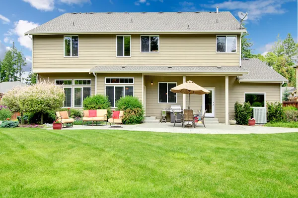 Hermosa casa grande con patio trasero con zona de estar y paraguas . — Foto de Stock