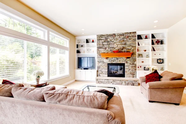 Gran salón luminoso con chimenea y sofás beige . — Foto de Stock