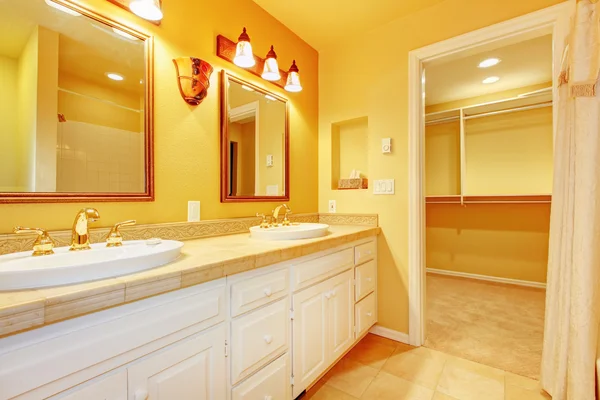 Białe szafki i złoto żółte ściany w łazience. — Zdjęcie stockowe