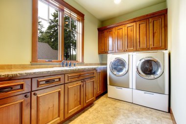 Luxury laundry room with wood cabinets.
