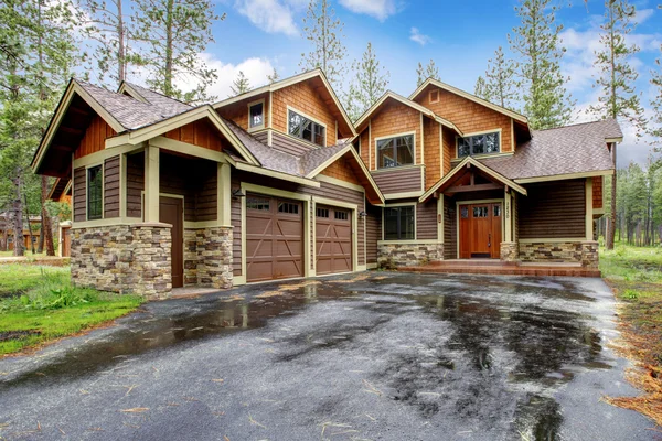 Large mountain cabin house with stone and wet driveway. — Stock Photo, Image