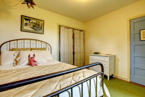 Dormitorio de casa de campo con cama de hierro y puerta vieja . — Foto de Stock