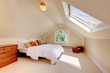 Attic modern bedroom with white bed and skylight. clipart