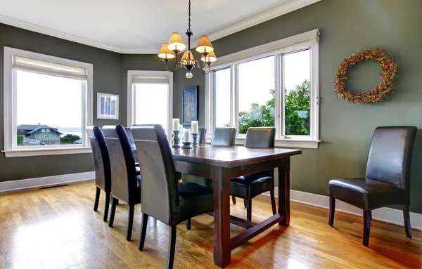 Grande sala de jantar verde com cadeiras de couro e grandes janelas . Fotos De Bancos De Imagens