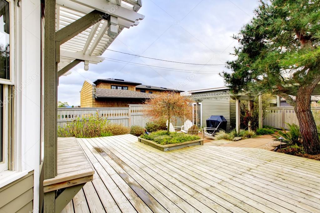 Spring backyard with large deck and wood structures.