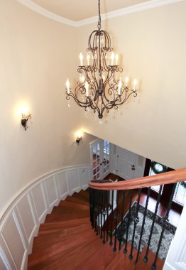 Luxury curved staircase with chandelier and harwood. clipart