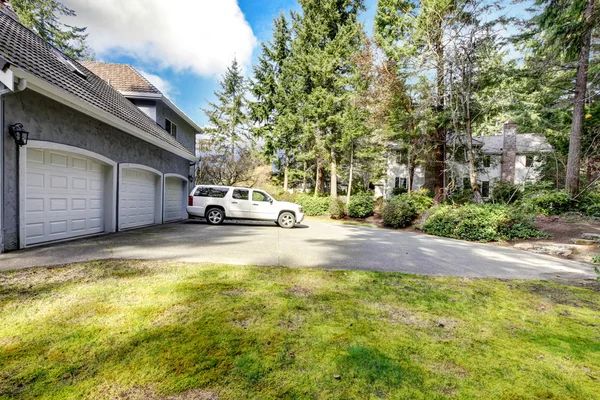 Three car garage and white large car with driveway. — Stock Photo, Image