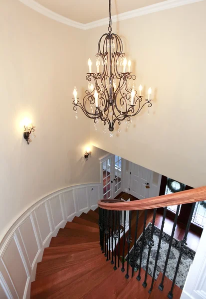 Luxury curved staircase with chandelier and harwood. — Stock Photo, Image