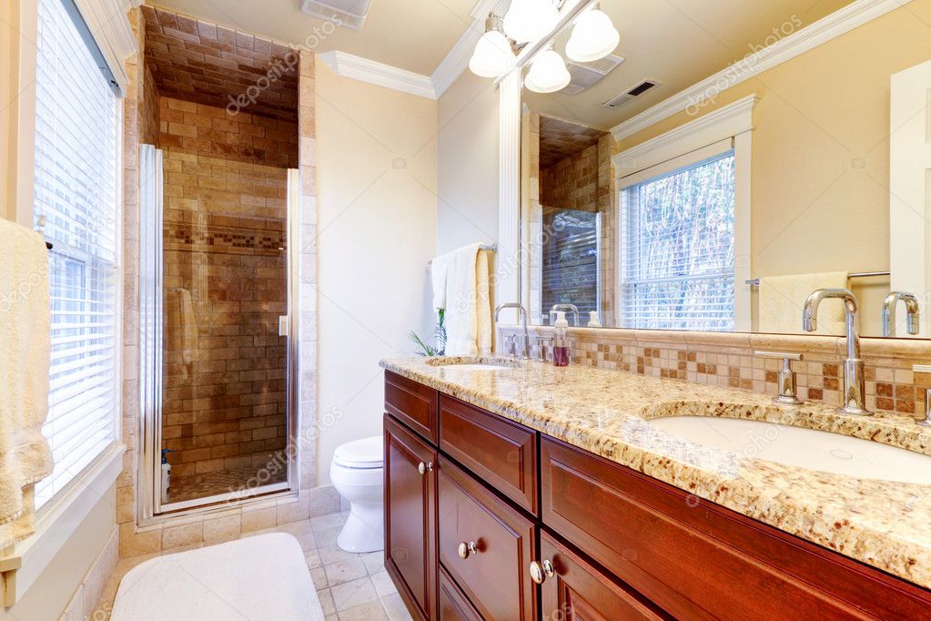 Large bathroom with cherry and granite countertop. Stock Photo
