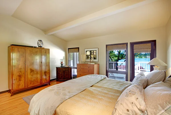 Moderní luxusní ložnice s výhledem na postel, komoda a jezero. — Stock fotografie
