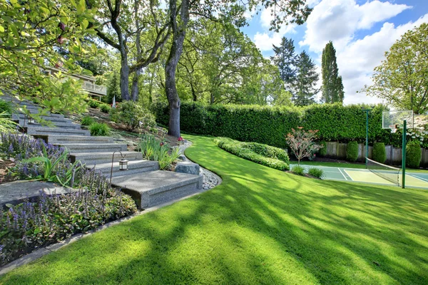 Pista de tenis con paisaje de casa y césped verde brillante . — Foto de Stock