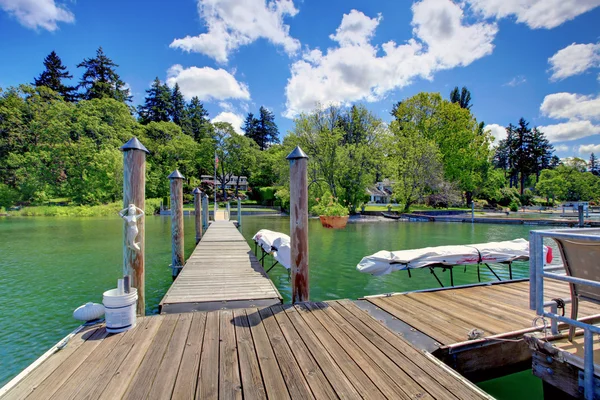 Lago con molo lungo in legno e zattera privata . — Foto Stock