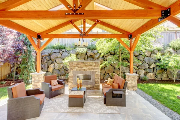 Terrasse extérieure couverte avec cheminée et mobilier . — Photo