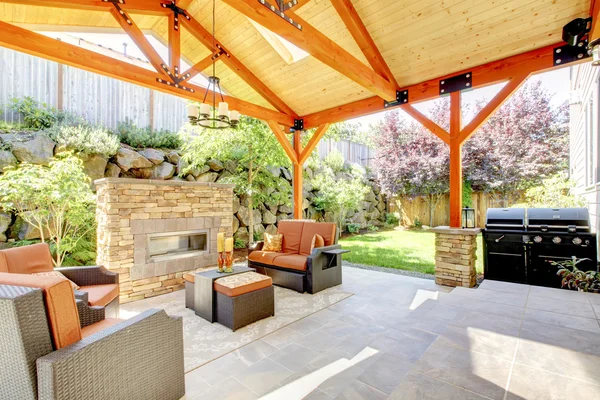 Exterior covered patio with fireplace and furniture. — Stock Photo, Image