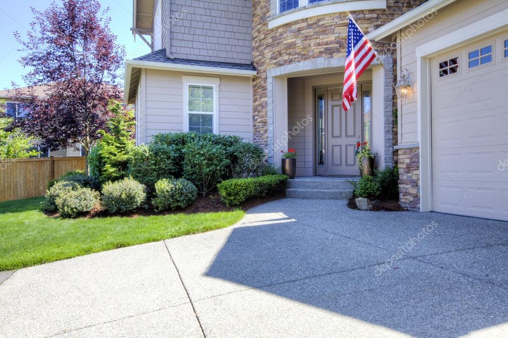 House exterior with driveway and American flag.