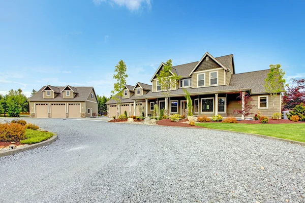 Grote boerderij landhuis met grind oprit en groene landschap. — Stockfoto