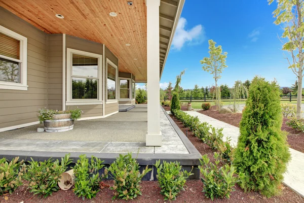 Großes Bauernhaus mit langer überdachter Veranda. — Stockfoto