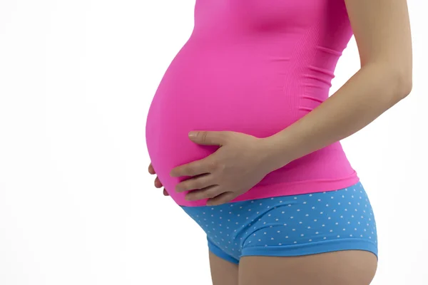 Zwangere vrouw holding buik in roze en blauw. — Stockfoto