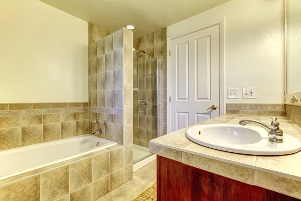 Bathroom with tub, small shower and wood cabinets. — Stock Photo, Image